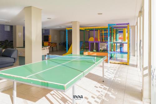 a ping pong table in the middle of a room at VOA Plazza Hotel in Águas de Lindóia