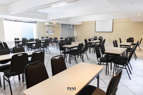 an empty classroom with tables and chairs at VOA Plazza Hotel in Águas de Lindóia