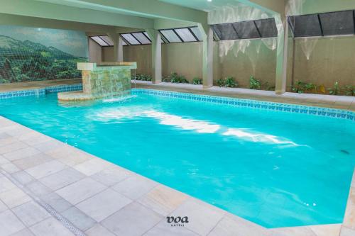 a large swimming pool in a hotel room with a swimming pool at VOA Plazza Hotel in Águas de Lindóia
