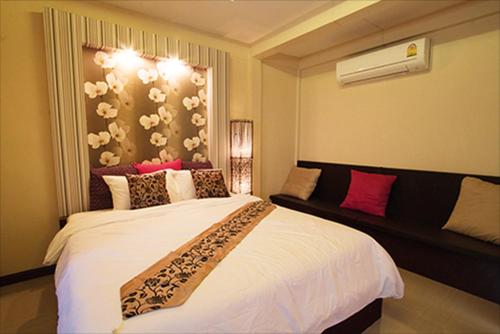 a bedroom with a large white bed and a window at The Vista Pool Villa in Kanchanaburi