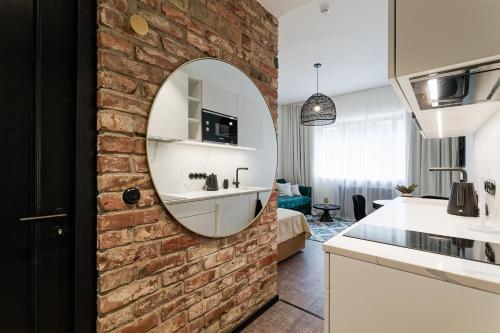 ein Badezimmer mit einer Backsteinwand und einem Spiegel in der Unterkunft Old Town Studio Apartment Aia 5a in Tallinn