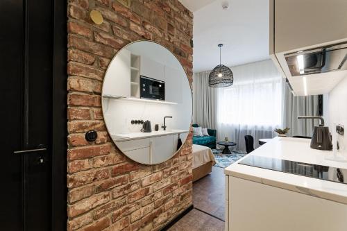 a bathroom with a brick wall and a mirror at Old Town Studio Apartment Aia 5a in Tallinn