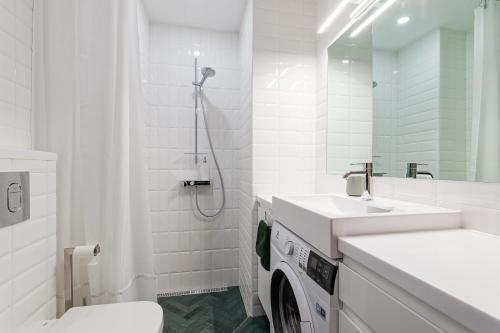 a white bathroom with a sink and a washing machine at Old Town Studio Apartment Aia 5a in Tallinn