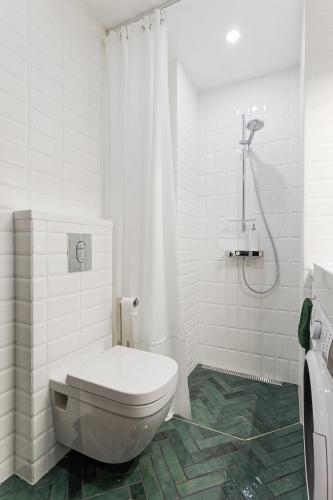 a white bathroom with a toilet and a shower at Old Town Studio Apartment Aia 5a in Tallinn