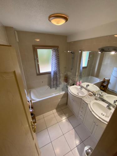 a bathroom with a tub and a sink and a bath tub at Chaleureux appartement T4 cosy, Font Romeu Odeillo Via in Font-Romeu-Odeillo-Via