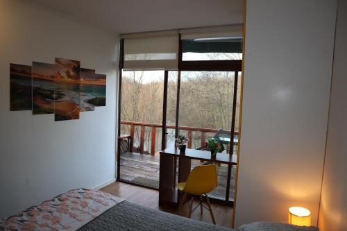 a bedroom with a bed and a view of a balcony at Cabañas Habitainer BordeRio in Concepción