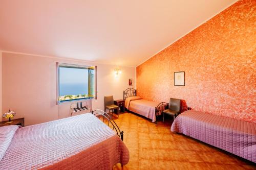 una camera d'albergo con tre letti e una finestra di Appartamento Ilaria in Villa Laura a Scala