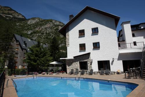 a hotel with a swimming pool in front of a building at Hotel & Spa Real Villa Anayet in Canfranc-Estación