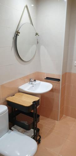 un bagno con lavandino, specchio e WC di Piso puerto Foz a Foz