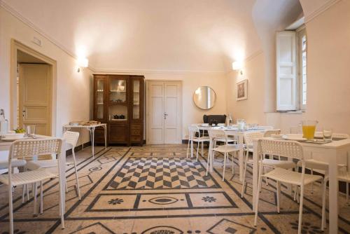 a restaurant with white tables and chairs and a checkered floor at Villa Polara in Modica