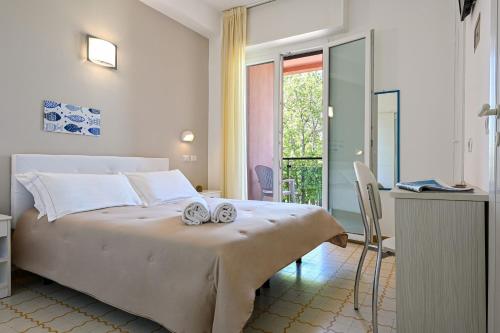 a bedroom with a large bed with two towels on it at Amadei Hotel Promenade in Pesaro