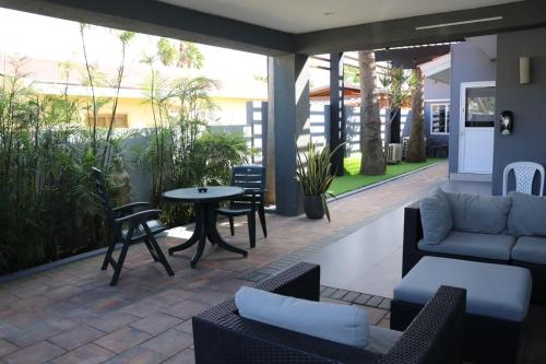 a patio with a couch and a table and chairs at Brown's 1 Bedroom Apartment in Palm-Eagle Beach