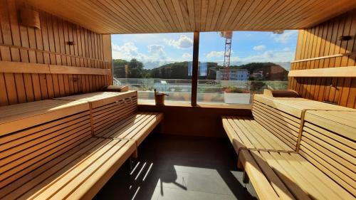 a sauna with wooden benches and a large window at Viktoria Deluxe direkter Meerblick in Ostseebad Sellin