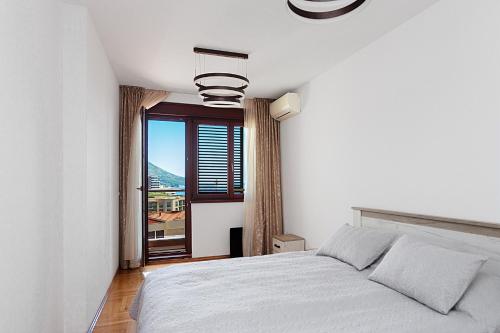 Habitación blanca con cama y ventana en Three bedroom spacious apartment Anatolia, en Budva