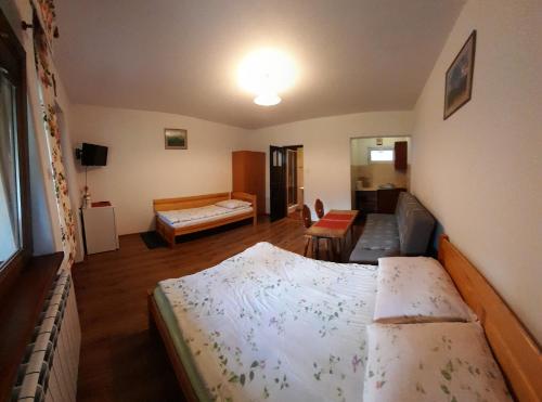 a bedroom with a bed and a living room at Pokoje gościnne Kozica in Zakopane
