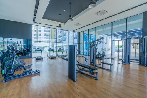 a gym with cardio equipment in a building with windows at Cozy 3-bedroom condo with pool 6 pax - Semarak in Kuala Lumpur