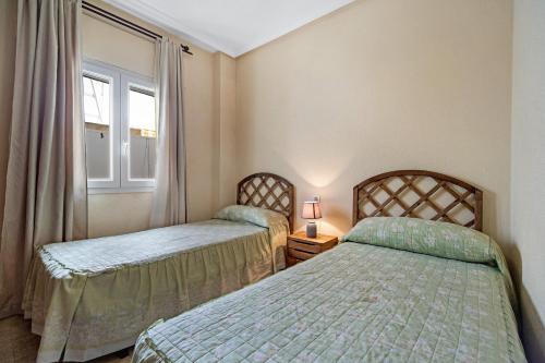 sypialnia z dwoma łóżkami i oknem w obiekcie Apartamento Colibri w mieście Puerto Real
