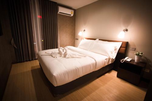 a bedroom with a large bed with white sheets at C U Inn Bangkok in Bangkok