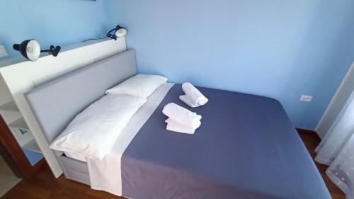 a blue bedroom with a bed with two pillows at Villa Jasna in Duino