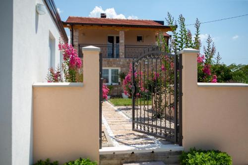 a gate in front of a house with flowers at Villa Bali - Aladinici in Stolac