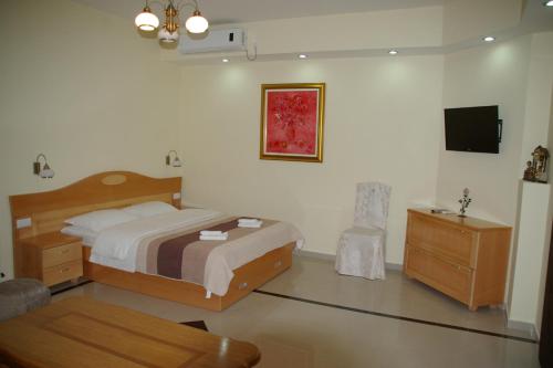 1 dormitorio con cama, mesa y TV en Apartments Drina, en Višegrad