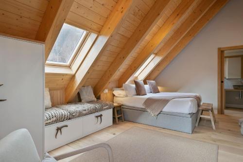 a attic bedroom with two beds and a window at Luderna - Duplex Corilha in Gessa