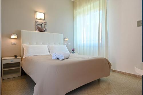 a bedroom with a large white bed and a sink at Amadei Hotel Promenade in Pesaro
