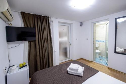 a room with a bed and a television and a bathroom at Casa Maria in Constanţa