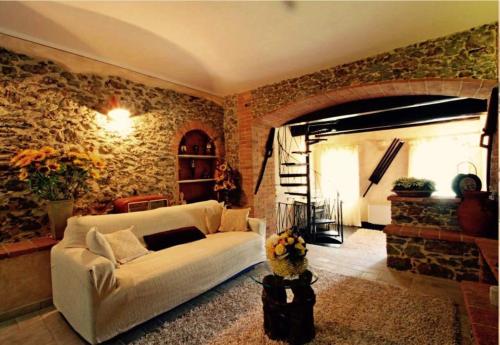 セラヴェッツァにあるIL PICCOLO PARADISOの白いソファとレンガの壁が備わるリビングルーム