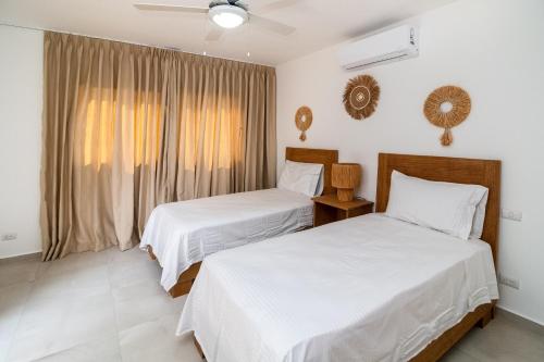 a bedroom with two beds and a window at Stella Aparthotel, Las Terrenas in Las Terrenas