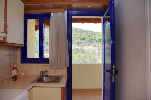 a kitchen with a sink and a window at STUDIOS ATHENA in Megalochori