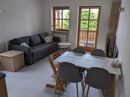 ein Wohnzimmer mit einem Tisch, Stühlen und einem Sofa in der Unterkunft Ferienwohnung Grenzenblick in Bayerisch Eisenstein