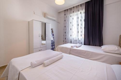 two beds in a room with a window at Assos Apart: Havuzlu sitede tamamı sizin 2 oda 1 salon daire in Belek