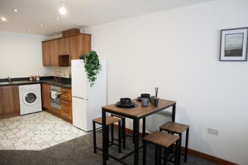 a kitchen with a small table and a refrigerator at The Kenway in Southend-on-Sea