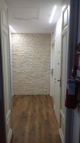an empty hallway with a brick wall and wooden floors at Hotel Galimberti in Turin
