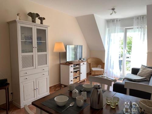 a living room with a large white cabinet and a table at Seerose in Kirchdorf
