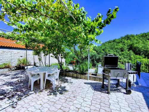 a patio with a table and a grill and a television at Casa rustica con terrazza e barbecue in Sessano Del Molise