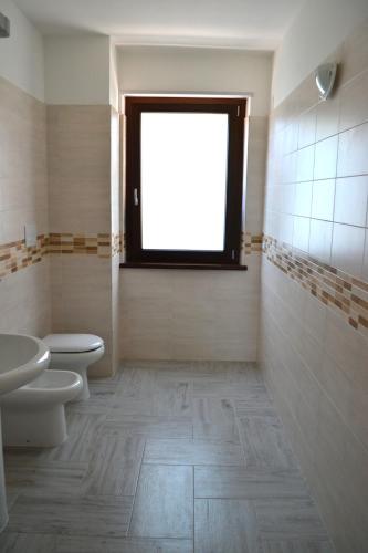 a bathroom with a toilet and a sink and a window at Agriturismo I 3 Fratelli in Sala Consilina