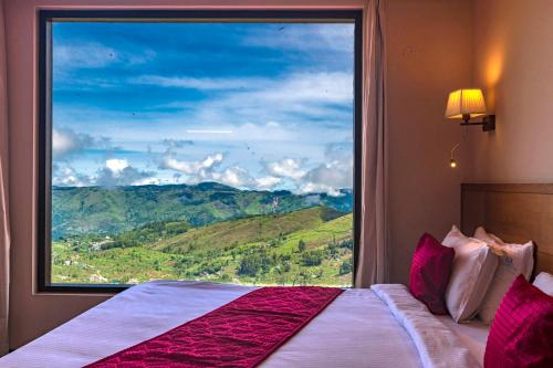 1 dormitorio con ventana grande con vistas a la montaña en Warmth Hill Crest, en Kodaikanal