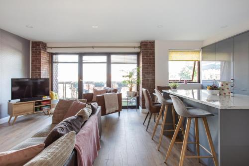 a living room with a couch and a table with chairs at New Lisburn Road Apartment - Free Parking in Belfast