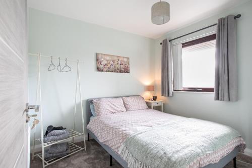 een slaapkamer met een bed en een raam bij New Lisburn Road Apartment - Free Parking in Belfast