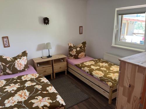 Cette chambre comprend 2 lits, une table et une fenêtre. dans l'établissement Chata Aurelia, à Nová Baňa
