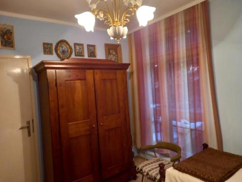 a bedroom with a wooden cabinet and a chandelier at Oriental Apartment in Plužine