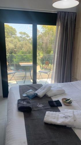 a bed with towels on it with a view of a patio at Melivia Luxury Suite in Nikiana