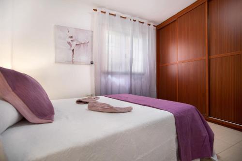 a pair of slippers sitting on a bed in a bedroom at Casita Amiga del Mar in Gran Tarajal