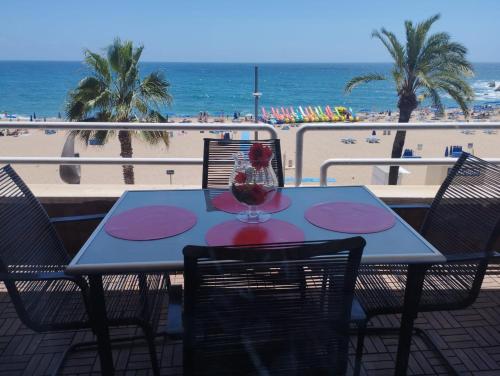 - une table avec un verre de vin au-dessus de la plage dans l'établissement Vivalidays Rosalia - LLoret de Mar centro, à Lloret de Mar