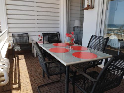 - une table avec des chaises et un vase sur la terrasse dans l'établissement Vivalidays Rosalia - LLoret de Mar centro, à Lloret de Mar