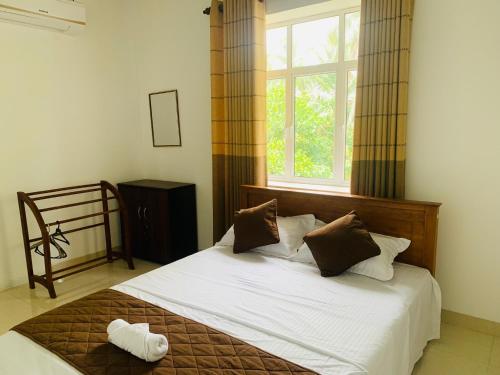 a bedroom with a white bed with a window at Breezy Brand-New Green Tops Villa in Battaramulla