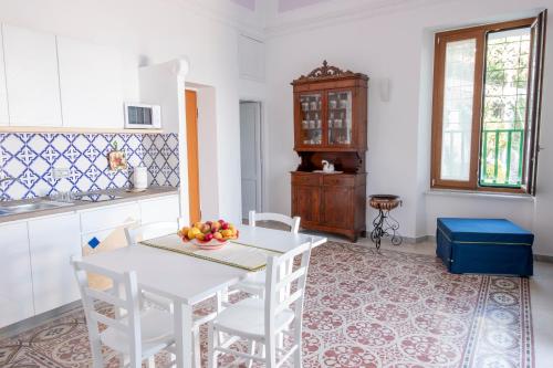a kitchen with a white table and white chairs at Emerald's Resort - Filomena in Conca dei Marini