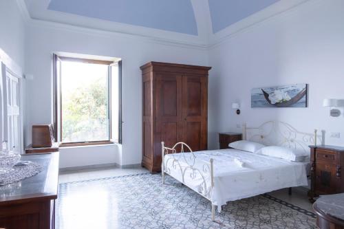 a bedroom with a white bed and a window at Emerald's Resort - Filomena in Conca dei Marini